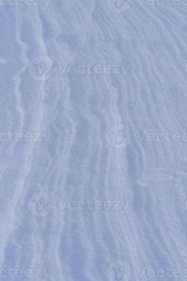 Schnee nach Wind Formen Weiß Segeltuch wirbelnd Muster. Licht, funkelnd, mit Eis Kristalle. einzigartig natürlich Textur und Ruhe Winter Landschaft. foto