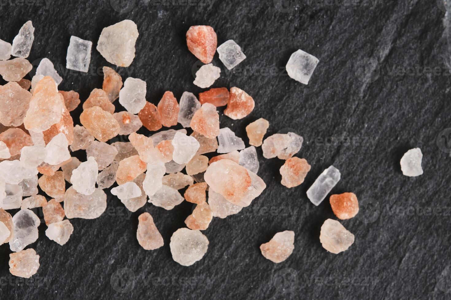 Kristalle von Rosa essbar Himalaya Salz- auf Hintergrund Schiefer Stein. foto