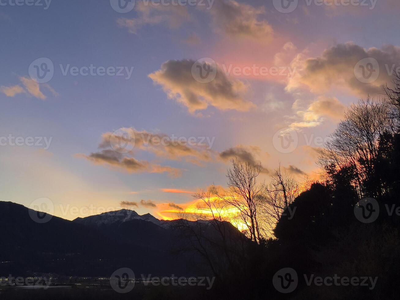 ein Sonnenuntergang Über das Berge mit Wolken und Bäume foto