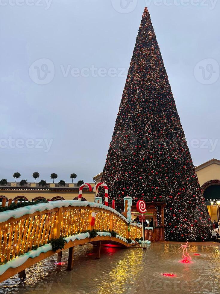 ein groß Weihnachten Baum im ein Einkaufszentrum mit ein Brücke foto