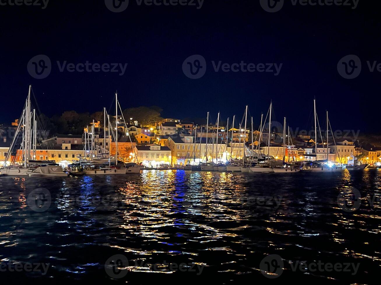 ein Hafen beim Nacht mit viele Boote und Gebäude foto