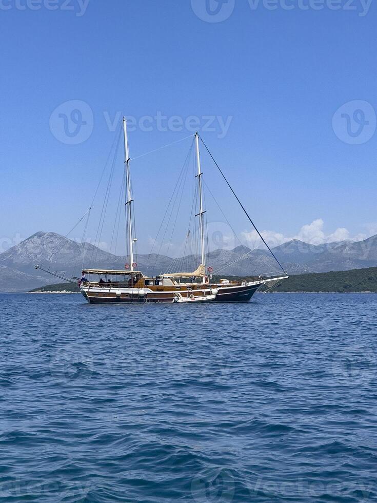 ein groß Boot schwebend im das Ozean mit Berge im das Hintergrund foto