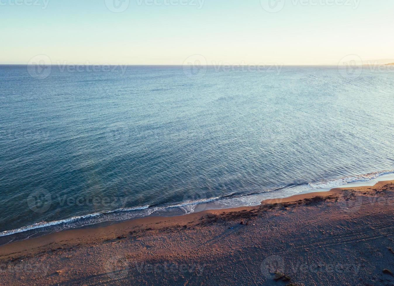 Mädchen und Hund am Strand bei Sonnenuntergang, Luftaufnahmen foto