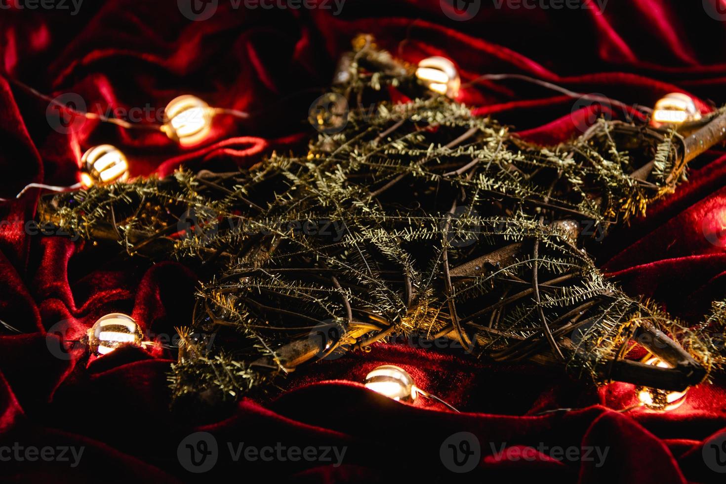 Weihnachtsdekoration, Stern und Lichter auf rotem Samt foto