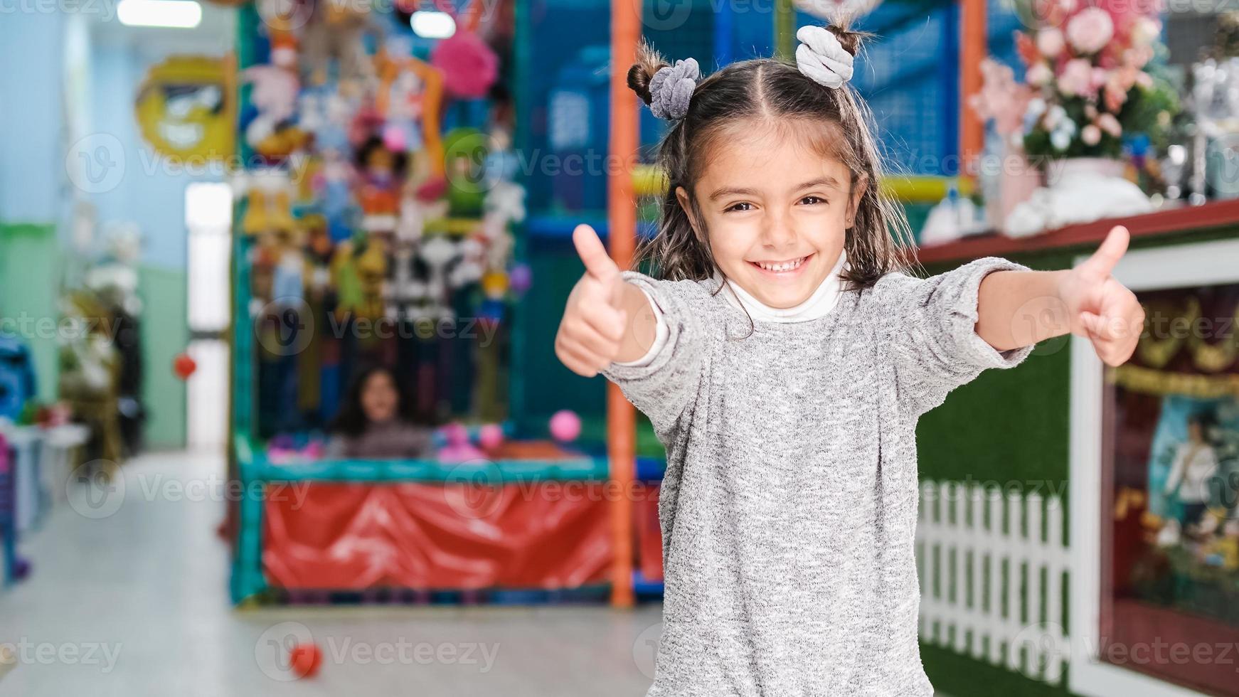 5-jähriges Mädchen, das auf dem Kinderspielplatz lächelt foto