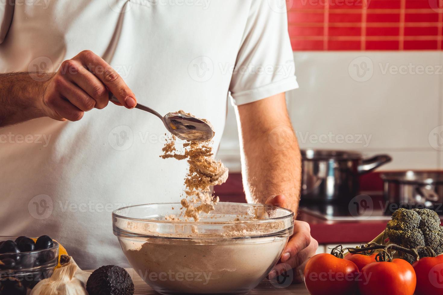 Mann, der den Seitan-Kochprozess zu Hause macht. wie man seitan zu hause veganes fleisch zubereitet foto
