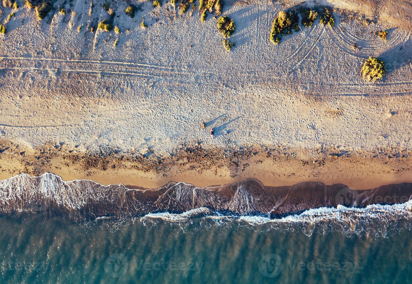 Luftaufnahmen eines Mädchens mit ihrem Hund an einem unberührten Strand, im Naturpark Punta Entinas, Almeria, Spanien? foto