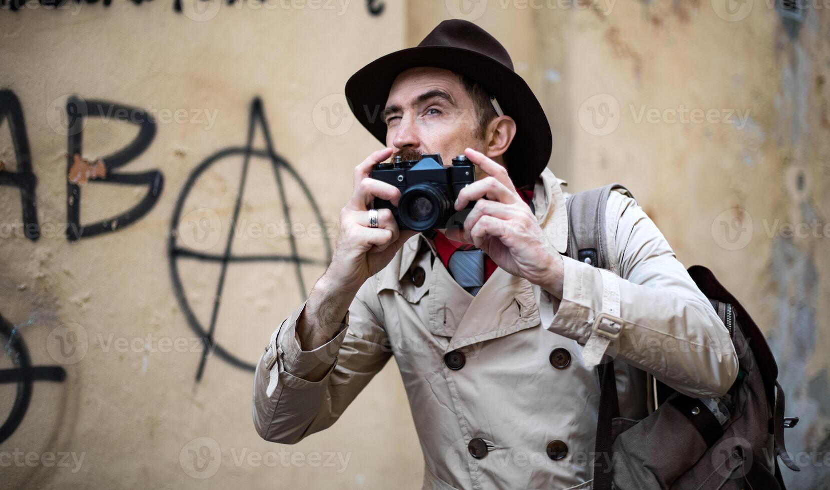 Detektiv nehmen Bilder im ein Stadt Slum mit seine Jahrgang Kamera foto