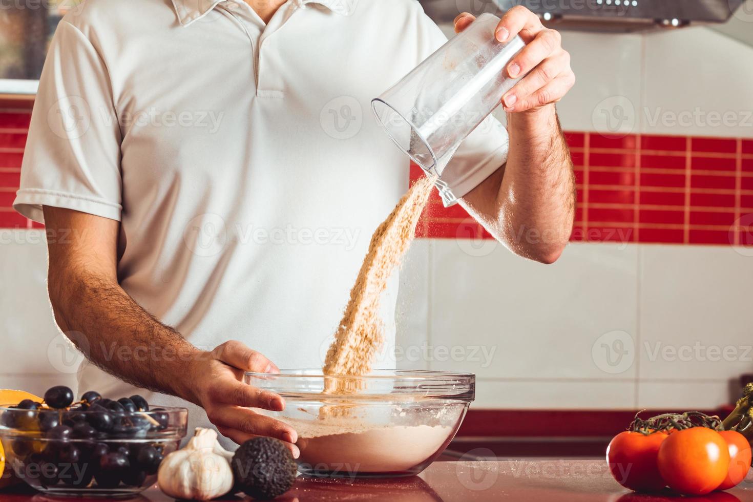 der junge Mann bereitete die Zutaten zum Kochen vor foto