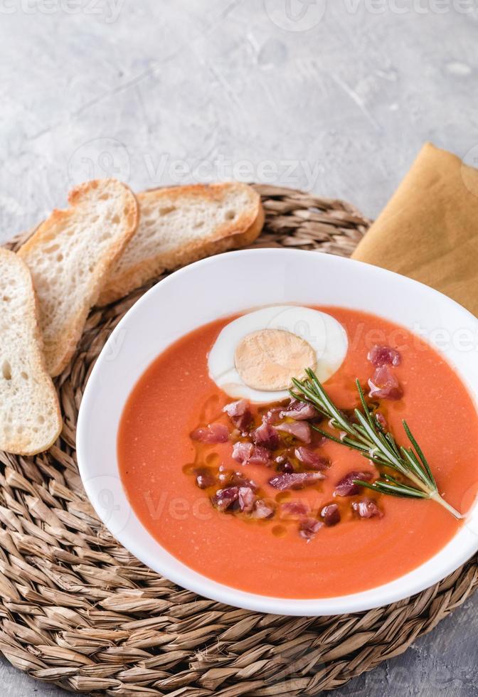 Salmorejo ist eine Tomatensuppe, ein traditionelles spanisches Gericht. mit Schinken und Eiern in einer Schüssel foto