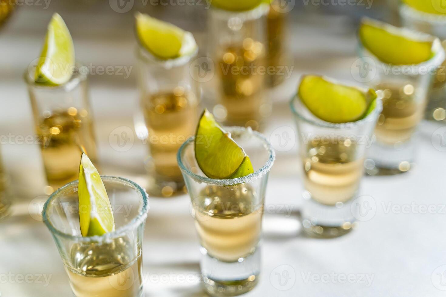 Tequila oder Wodka im kurz Brille mit ein Stück von Limette und Salz- auf das oben von jeder schön Stehen auf Weiß Tisch. Brille von Alkohol und Limette zum Bankett. Makro Schuss. foto