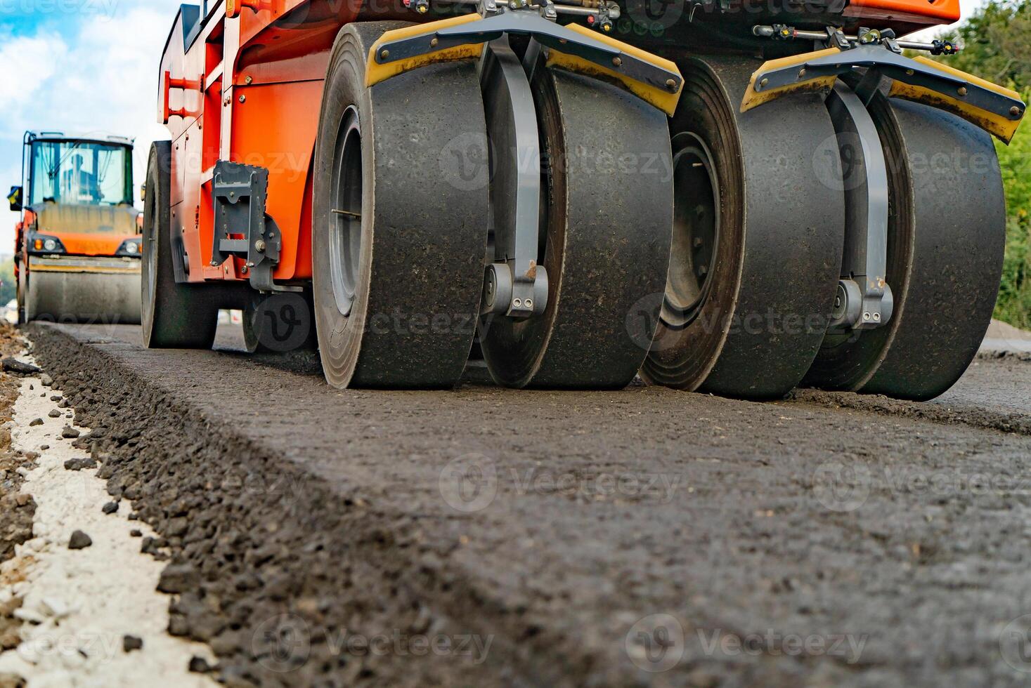 Asphalt Walze Das Stapel und Drücken Sie heiß Asphalt während Herstellung ein Neu Straße. Straße Reparatur Maschine mit schwer Vibration Walzen Verdichter foto