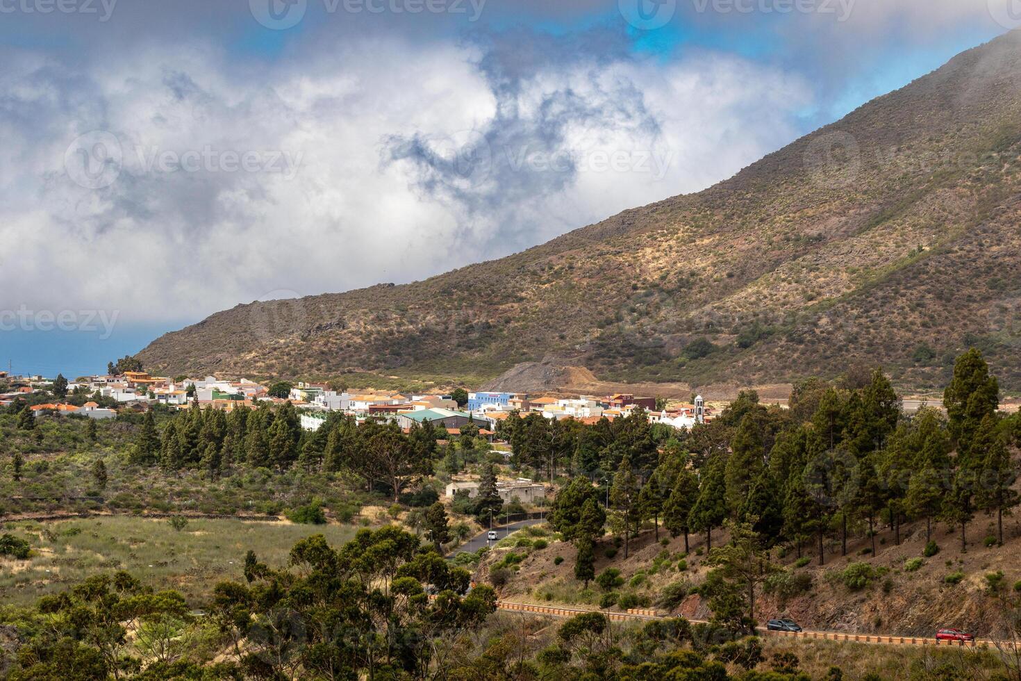 szenisch Aussicht von ein klein Dorf eingebettet im das Ausläufer von ein Berg unter ein wolkig Himmel Berg Landschaft mit Blau Himmel und Wolken im Teneriffa. foto