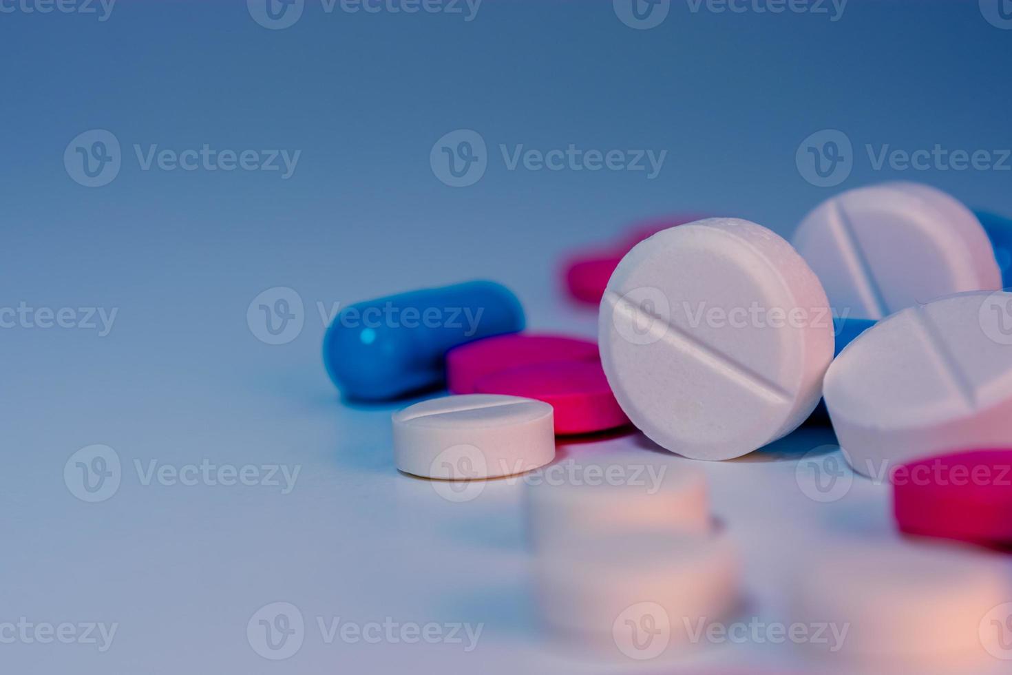 Mehrere verstreute Pillen auf dem Tisch Nahaufnahme auf einem bunten Hintergrund. foto