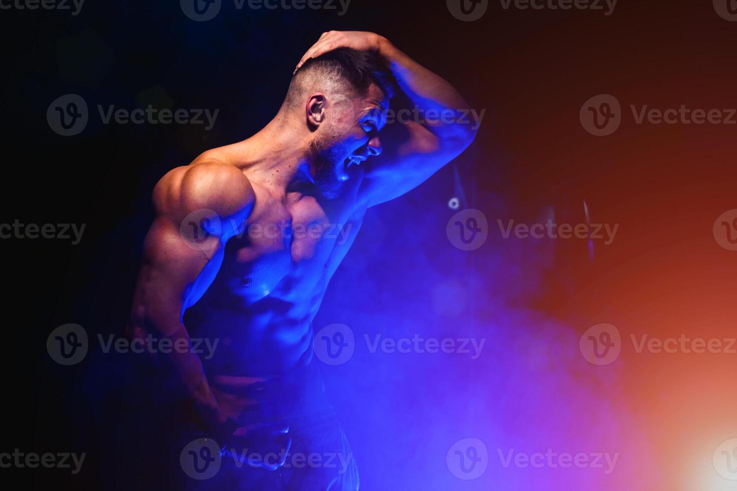 brutal stark sportlich Männer Pumpen oben Muskeln. trainieren und Bodybuilding Konzept. Blau Licht Filter. gut aussehend Mann mit nackt Torso. Fitness Modell- ist posieren. foto