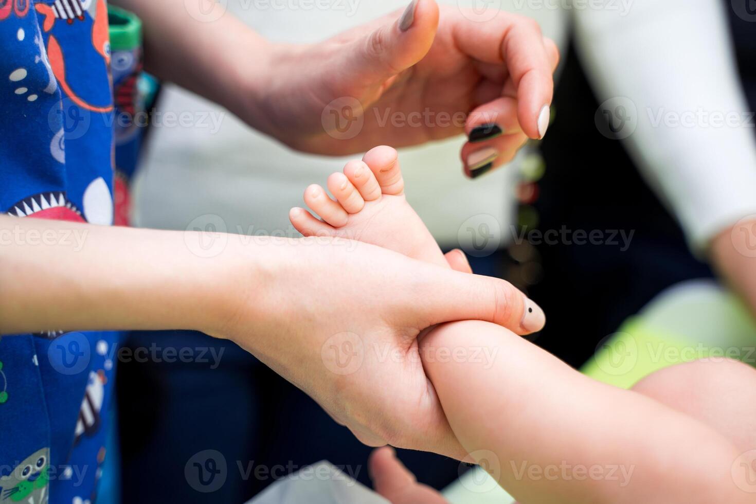 Kinderarzt Prüfung wenig Baby im Klinik. Nahansicht von ein Kinder Bein im Arzt Hände. foto