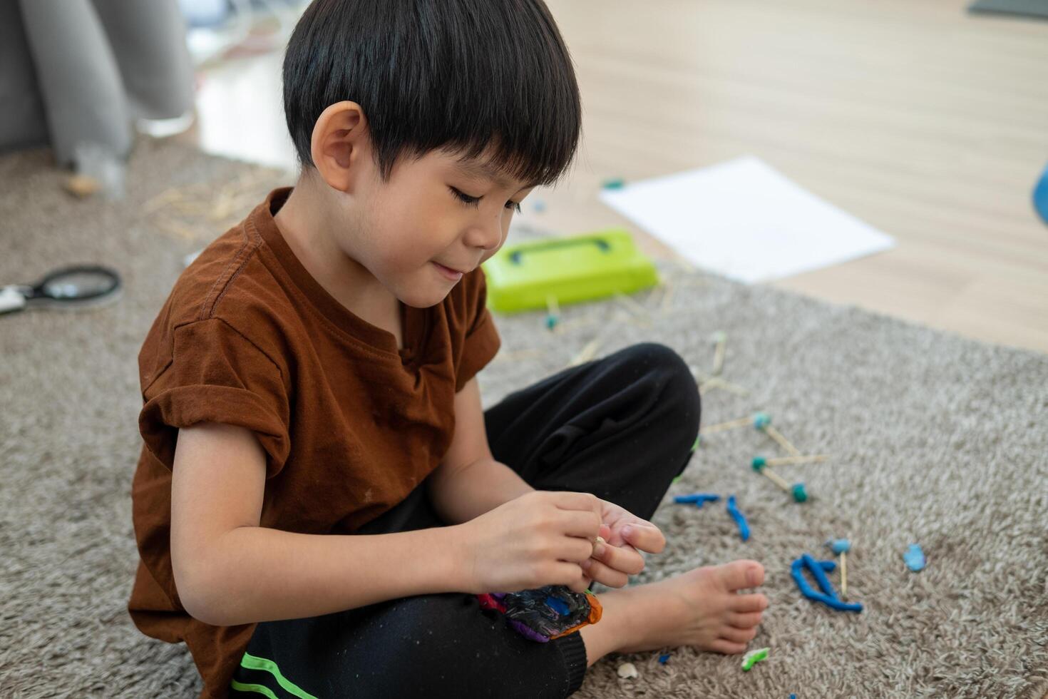 asiatisch Junge spielen mit Plastilin im das Zimmer foto