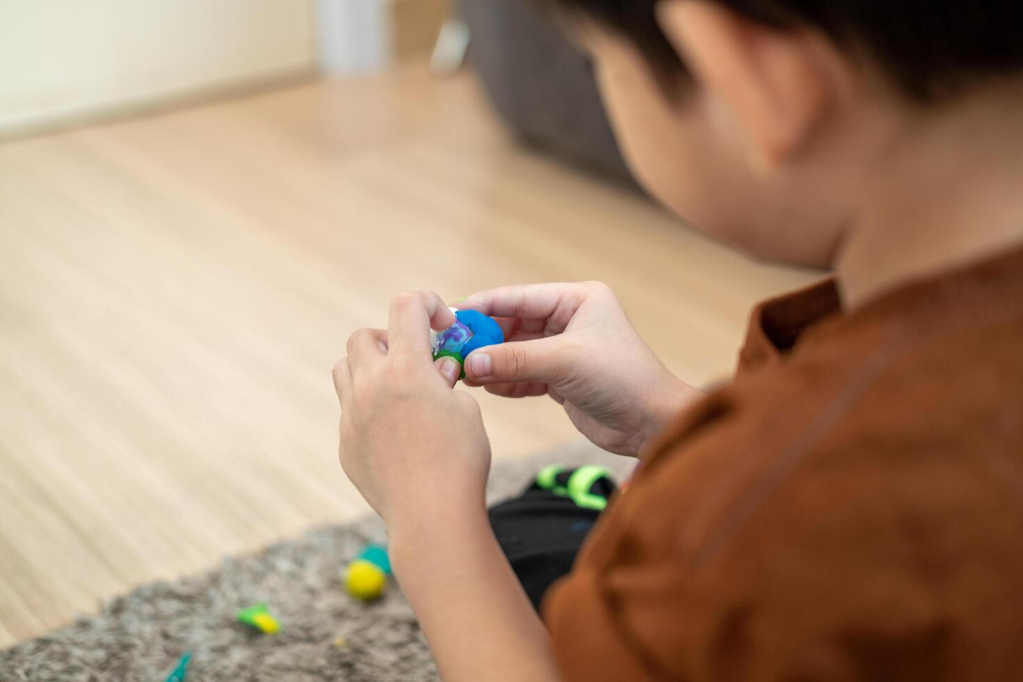 asiatisch Junge spielen mit Plastilin im das Zimmer foto