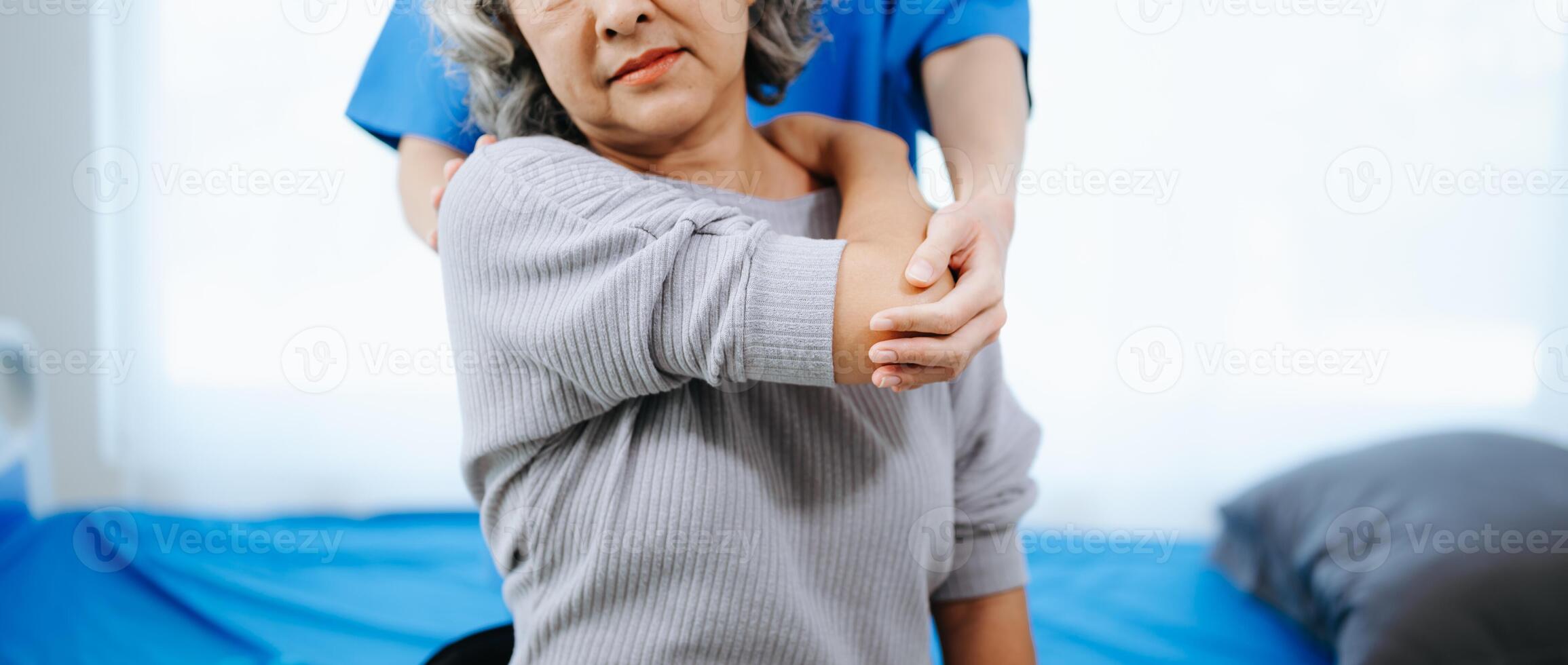 asiatisch Physiotherapeut Portion weiblich geduldig Dehnen Arm während Übung richtig mit Hantel im Hand während Ausbildung Hand foto