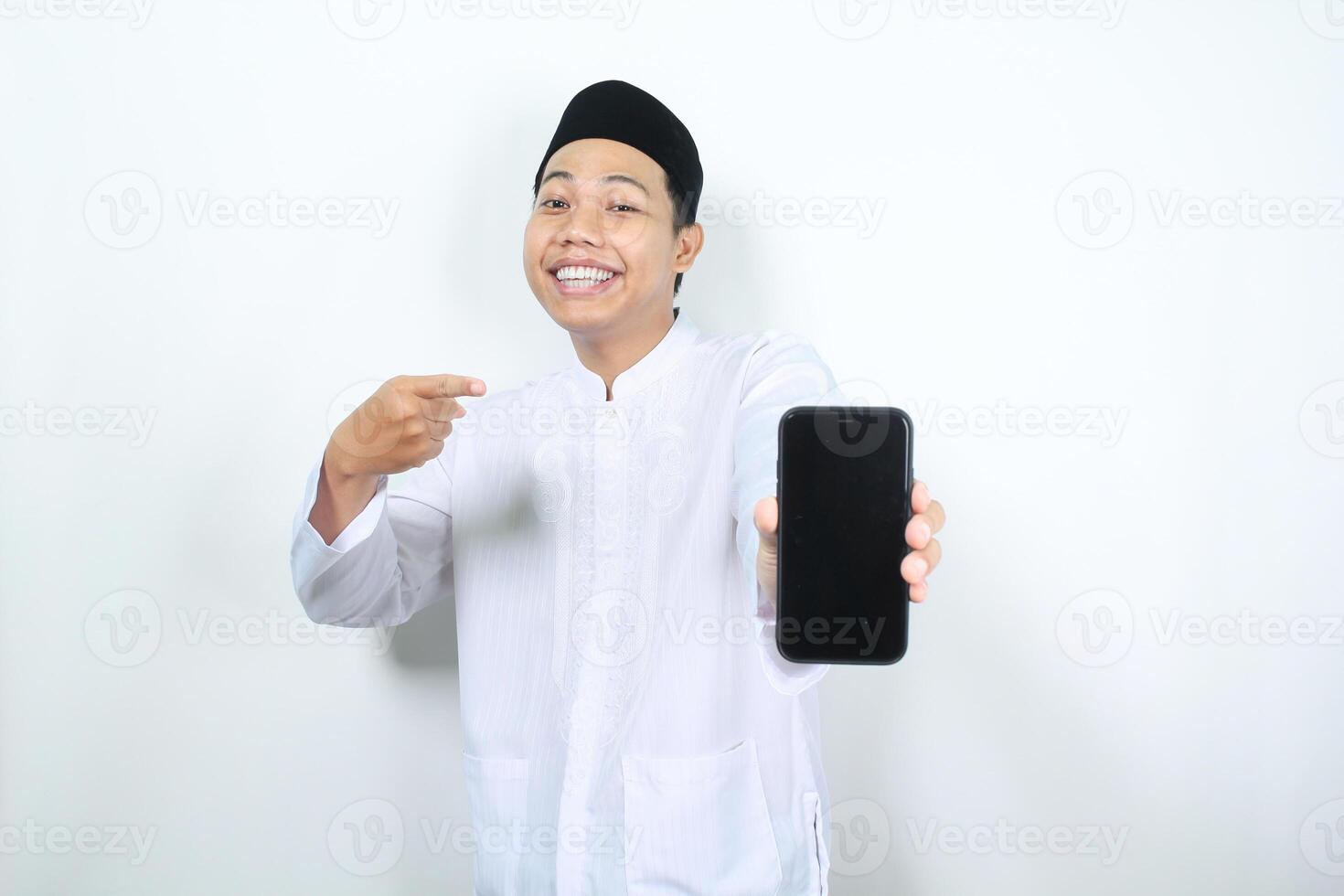 lächelnd asiatisch Muslim Mann zeigen zu Telefon Bildschirm Anzeige isoliert foto