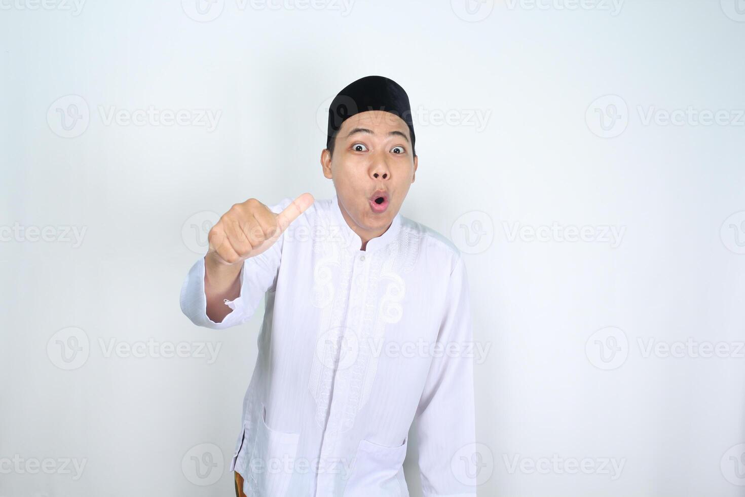 schockiert asiatisch Mann Muslim Show Daumen oben isoliert auf Weiß Hintergrund foto