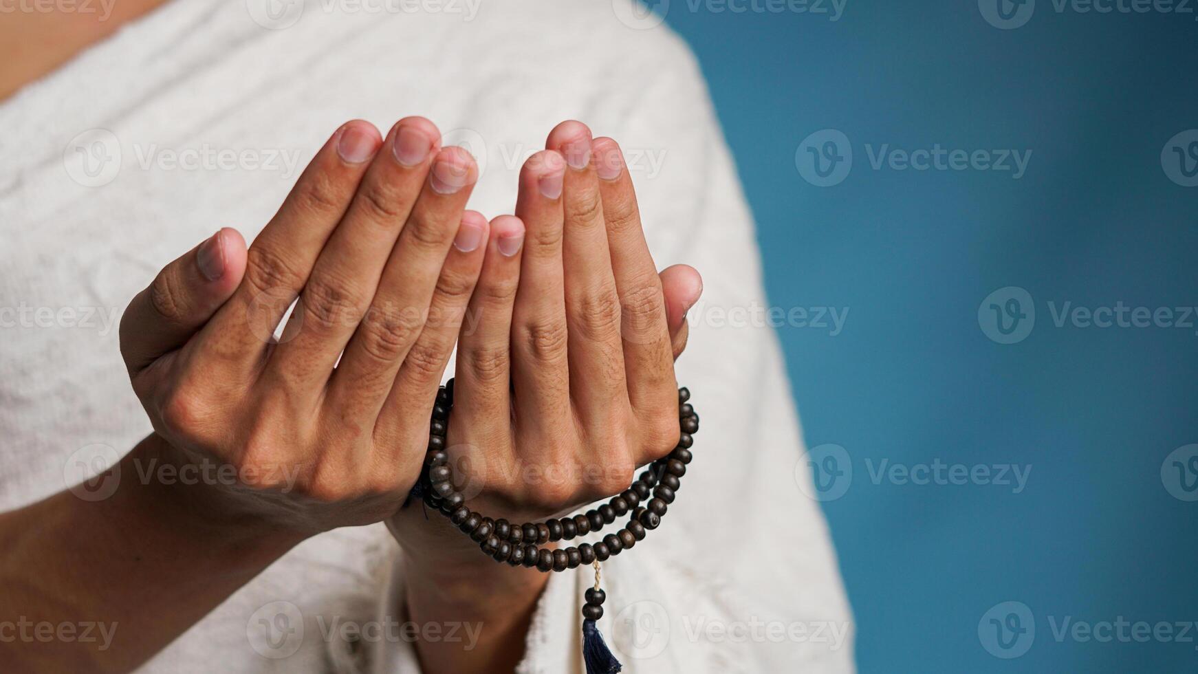 Muslim Mann tragen ihram Kleider ist beten mit Gebet Perlen im seine Hände foto