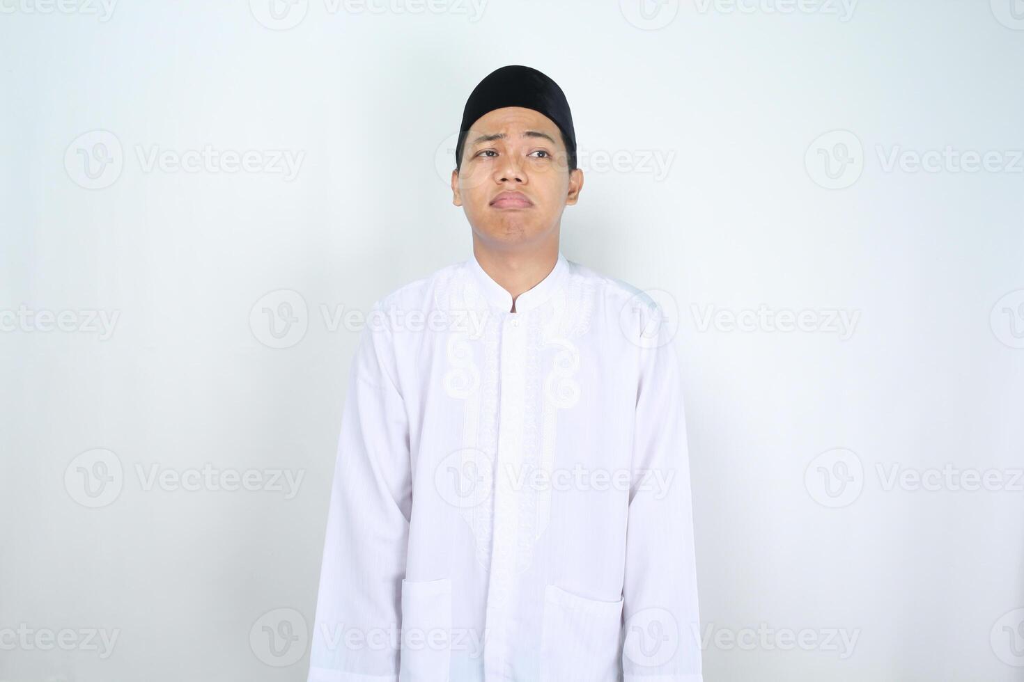 traurig asiatisch Muslim Mann suchen Oberer, höher Ecke mit betont Ausdruck isoliert auf Weiß Hintergrund foto