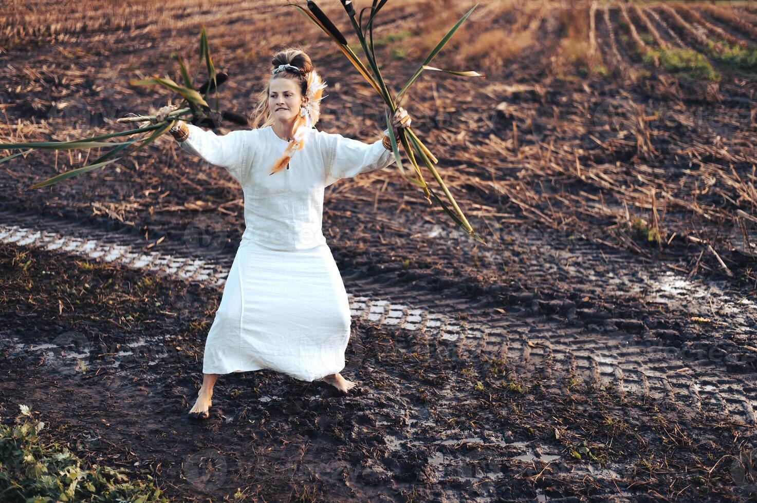 heiter jung Frau mit Schilf Tänze im farbig Rauch im ein Feld. foto