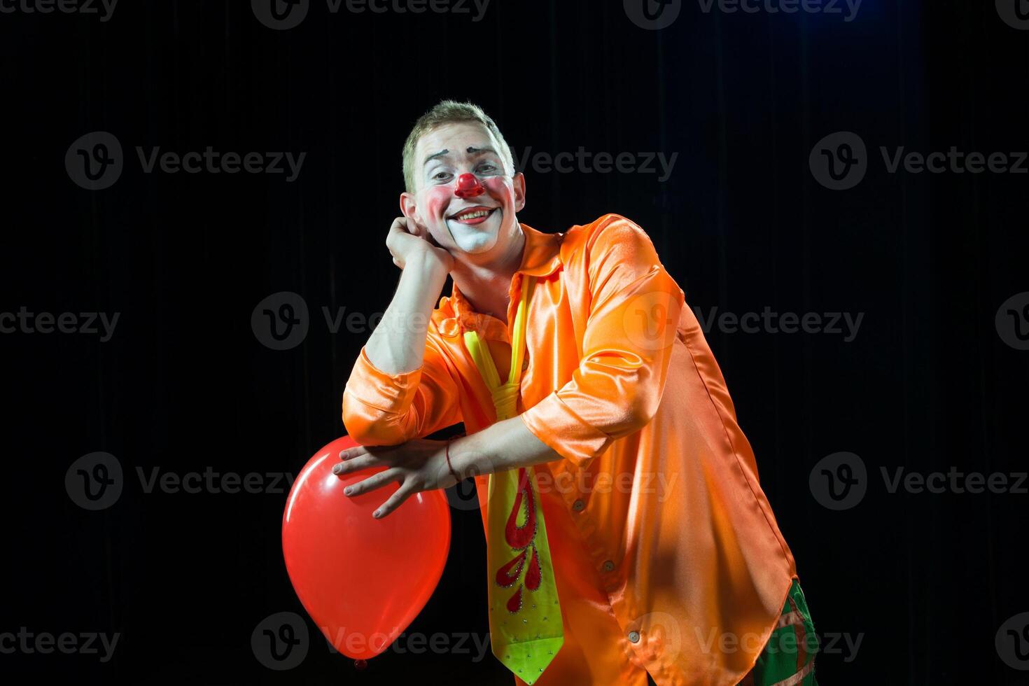 Zirkus Clown führt aus Nummer. ein Mann im ein Clown Outfit mit ein Spielzeug.a Mann im ein Clown Outfit mit ein Ballon foto
