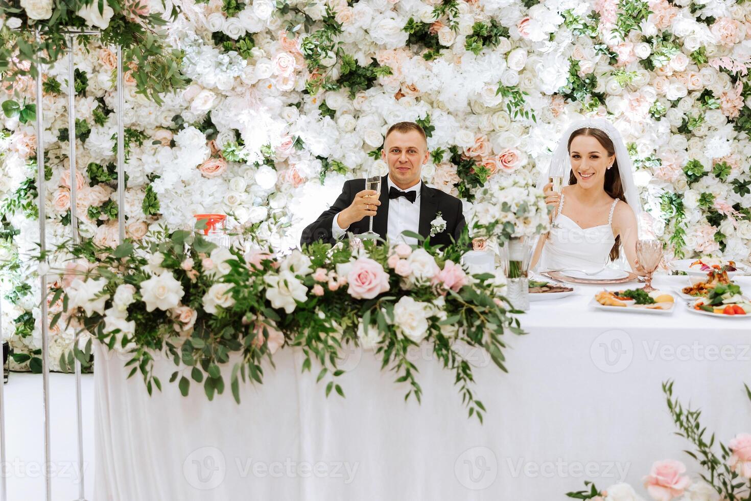 gestohlen Momente beim ihr Hochzeit Rezeption. jung Hochzeit Paar erziehen Champagner Brille während Hochzeit Feier foto