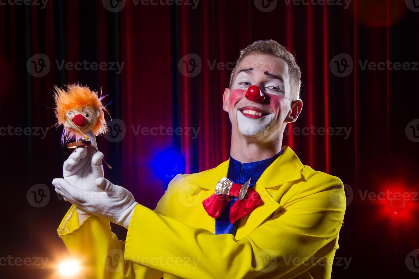 Zirkus Clown führt aus Nummer. ein Mann im ein Clown Outfit mit ein Spielzeug foto