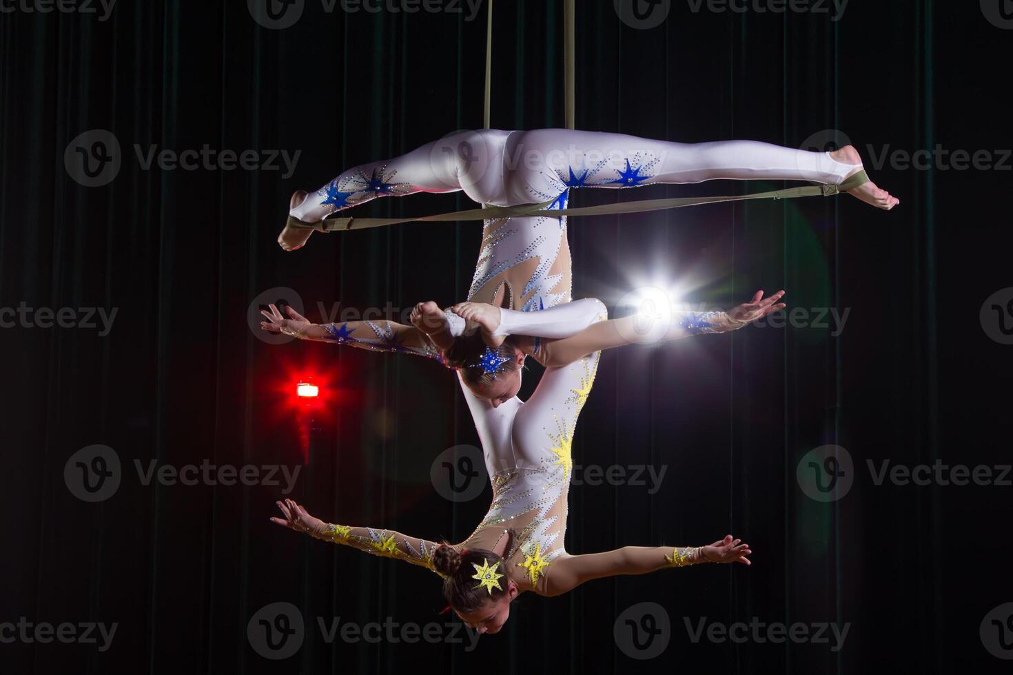 Zirkus Darstellerin Akrobat Leistung. zwei Mädchen ausführen akrobatisch Elemente im das Luft. foto