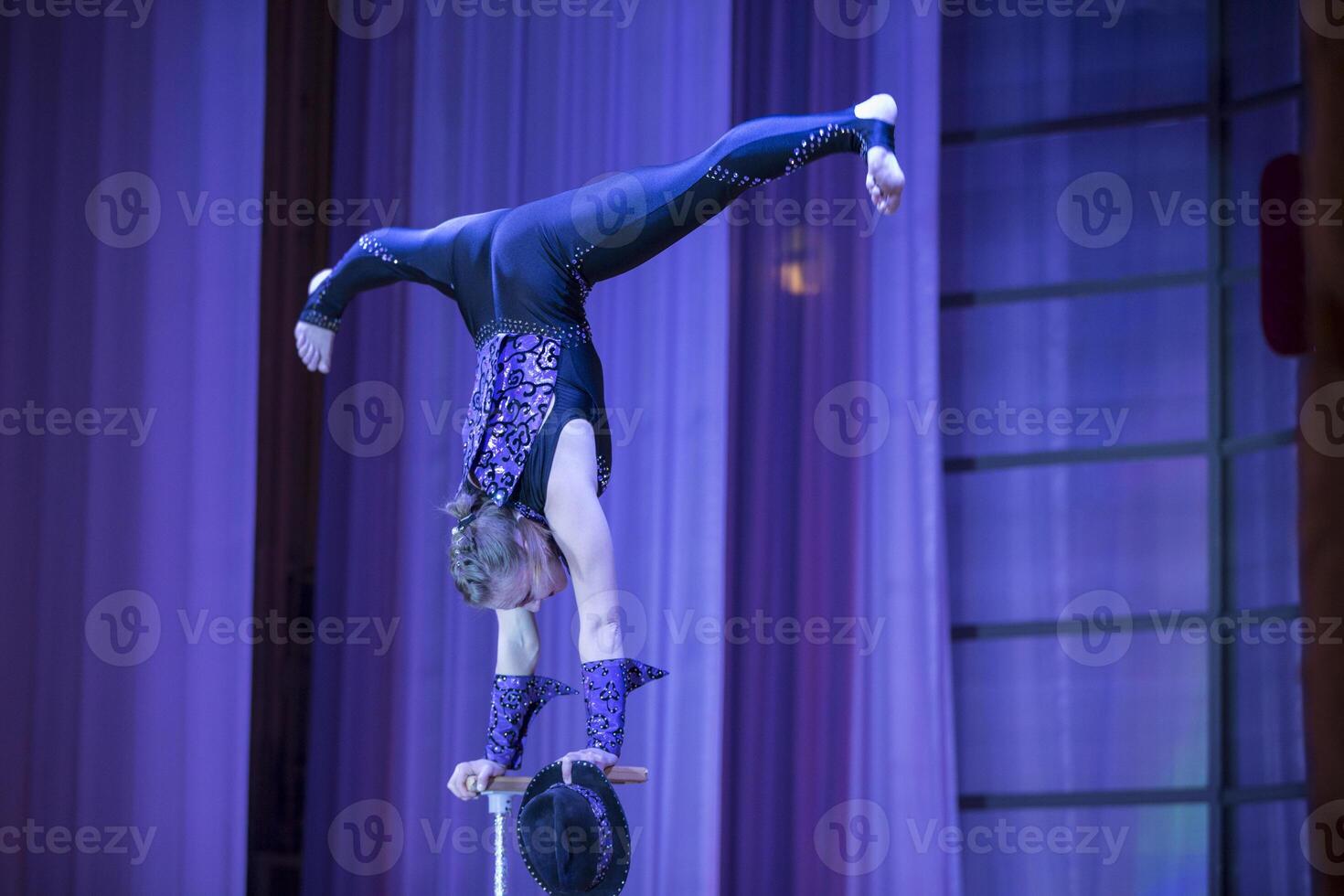 Weißrussland, Gomel, Juli 4, 2018. indikativ Ausbildung Zirkus Schulakrobatik Performance von das Schauspielerin.Mädchen mit ein flexibel körper.balancierend act.twine Zahl auf Bühne foto