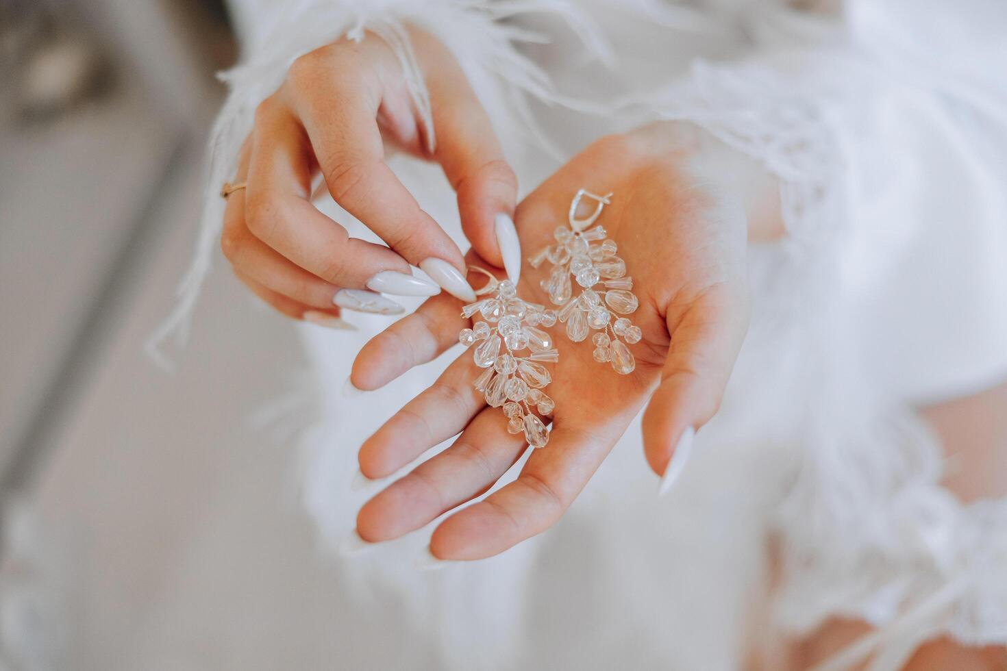 Nahansicht von ein schön Mädchen im Sanft Satin- Unterwäsche tragen Ohrringe. Hochzeit Morgen von das Braut. Werbung Dekorationen. ein Frau geht auf ein Datum. foto