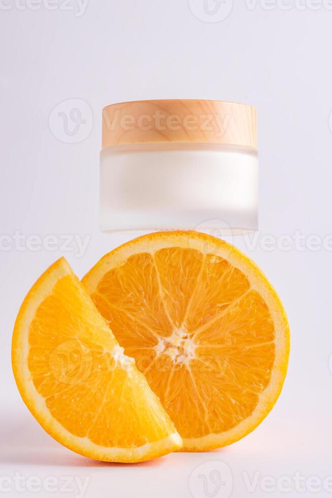 kosmetisch Krug mit natürlich Energie Vitamin c Haut Pflege. kosmetisch Sahne mit Scheiben von Orange auf Weiß Hintergrund foto