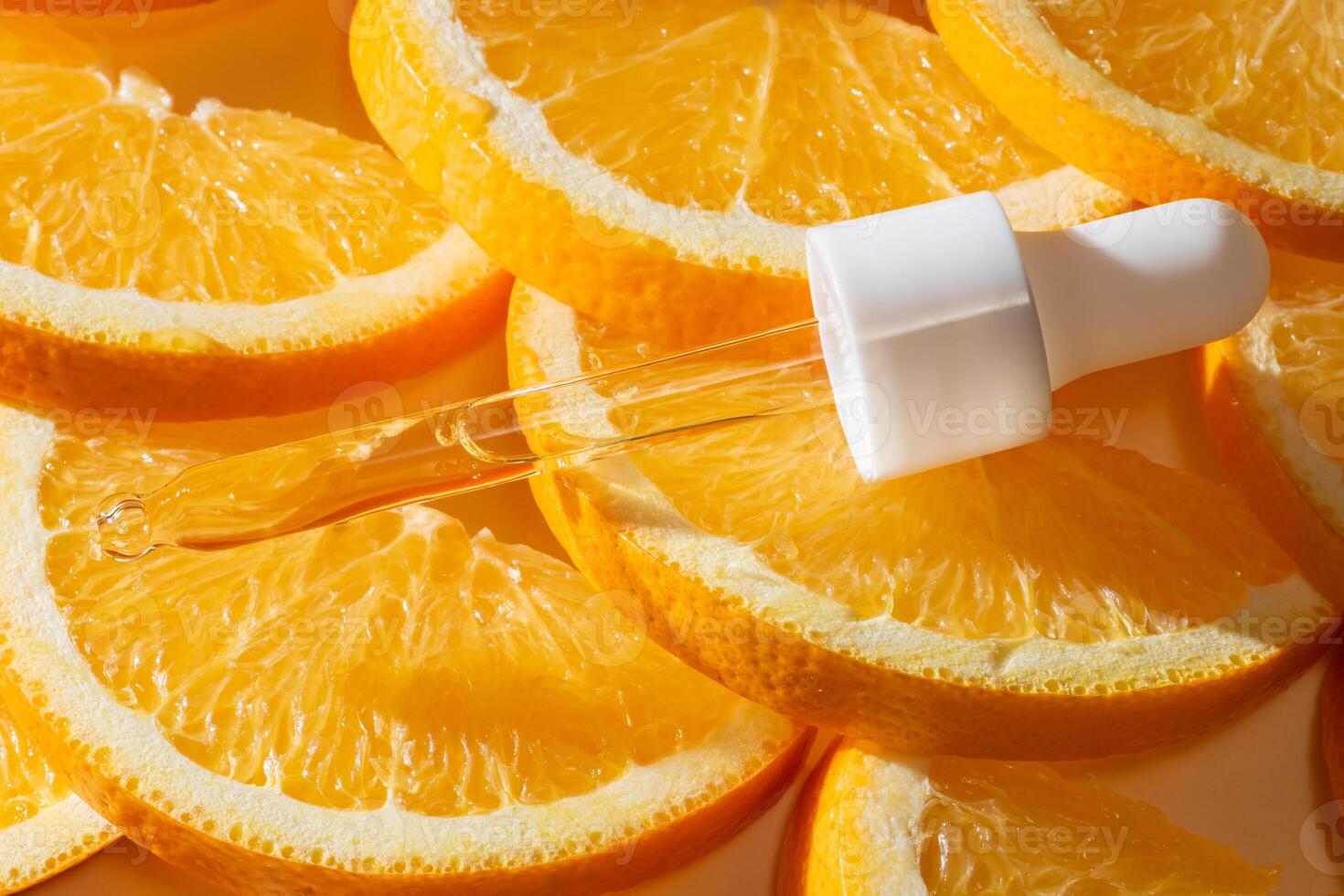 ein Nahansicht von ein Vitamin c Serum im ein Tröpfchen, umgeben durch frisch, beschwingt Orange Scheiben. Attrappe, Lehrmodell, Simulation foto