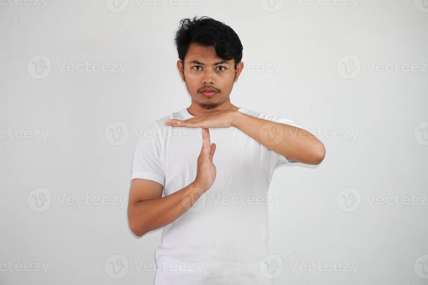 ernst jung asiatisch Mann geben Zeit aus Hand Geste tragen Weiß t Hemd isoliert auf Weiß Hintergrund foto