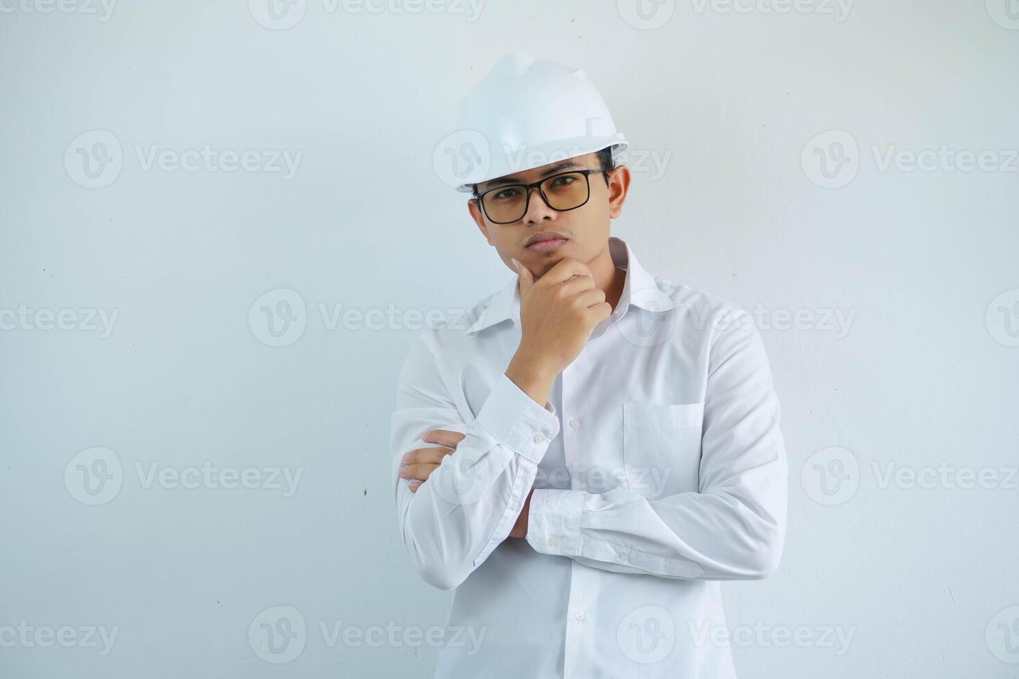 jung asiatisch männlich Ingenieur tragen Weiß schwer Hut halten Kinn Denken zum Konstruktion Arbeit isoliert auf Weiß Hintergrund, Kopieren Raum. foto