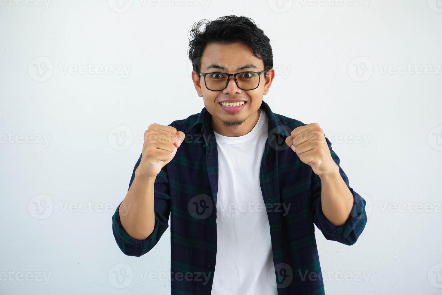 jung asiatisch Mann Brille suchen Kamera mit beide Hände geballt zeigen Aufregung isoliert auf Weiß Hintergrund. foto
