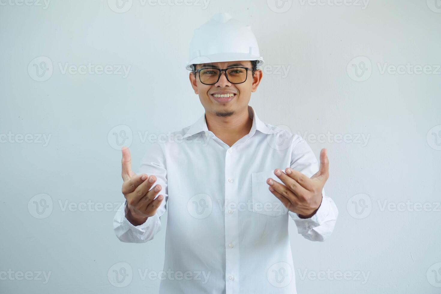 Architekt jung asiatisch Mann tragen Weiß Helm Stehen Über isoliert Weiß Hintergrund lächelnd freundlich öffnen Waffen Begrüßung. erfolgreich Geschäft. foto