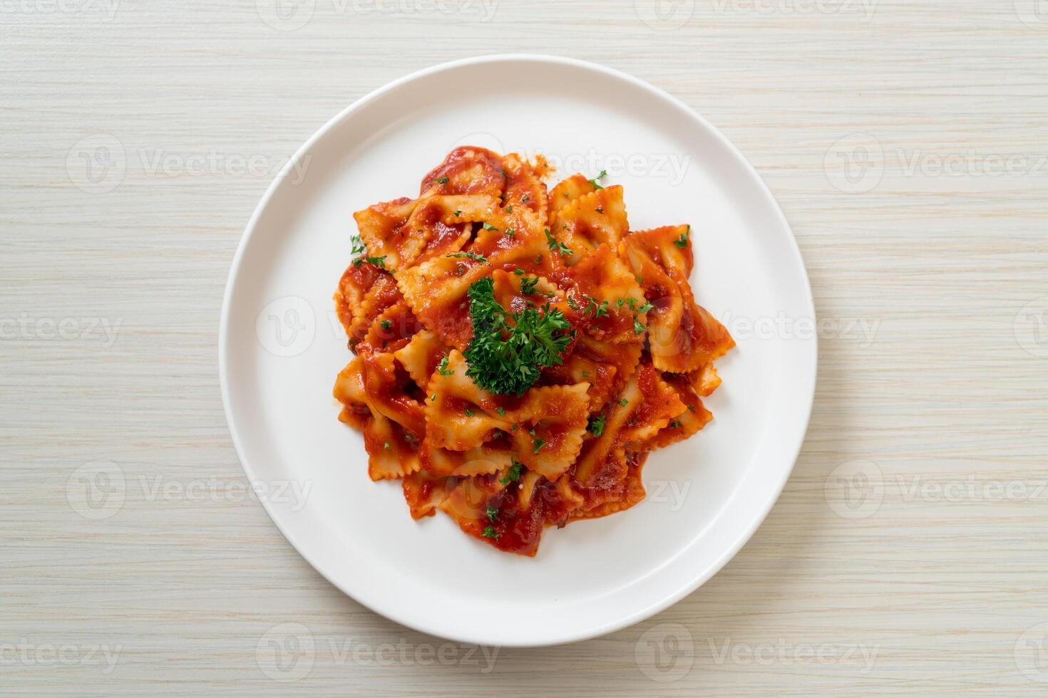 Farfalle Nudeln in Tomatensauce mit Petersilie foto