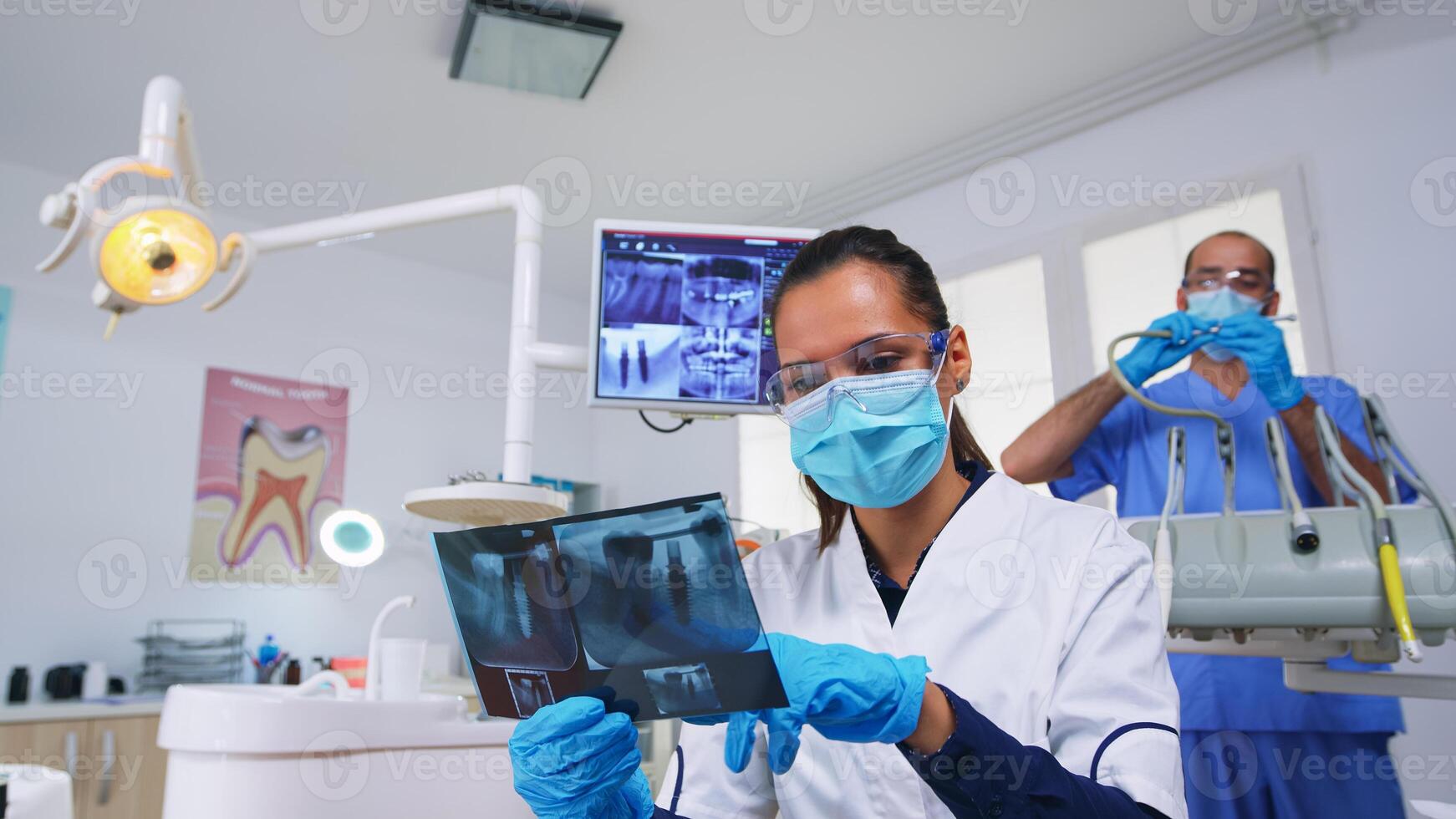 geduldig pov im Dental Büro Planung Chirurgie Schritte von Zähne Hohlraum, Zahnarzt zeigen auf Röntgen Bild. Stomatologie Arzt tragen schützend Maske und Handschuhe, Arbeiten im modern stomatologisch Klinik foto