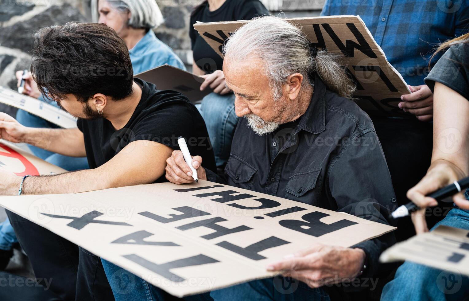 vielfältig Aktivisten mit anders Alter und ethnische Zugehörigkeit vorbereiten Protest Banner gegen finanziell Krise und global Inflation foto