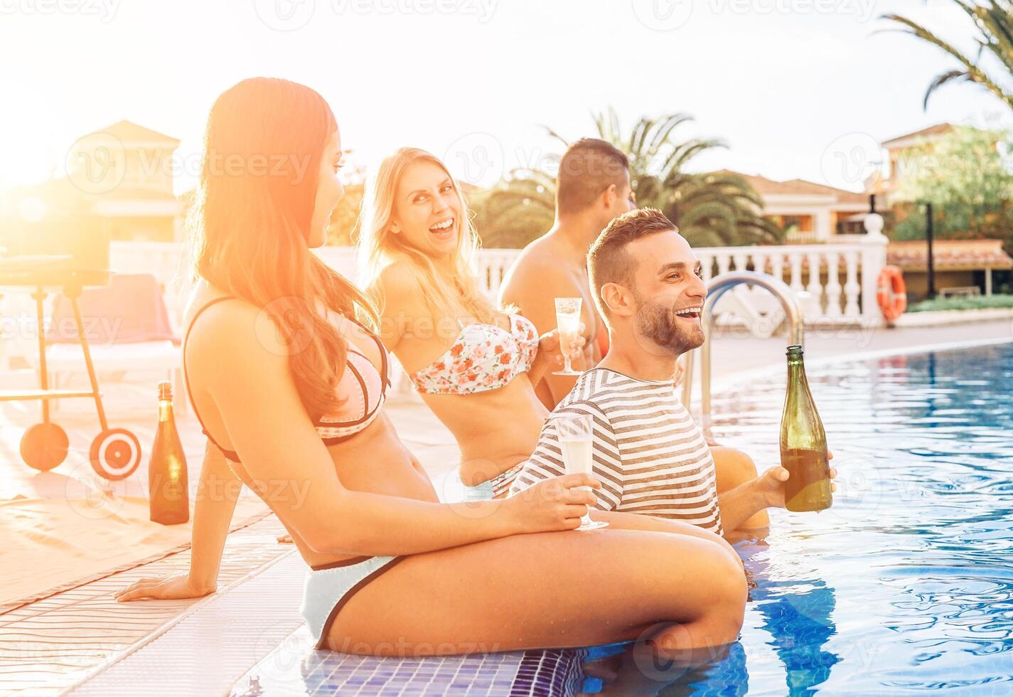 Gruppe von glücklich freunde Herstellung ein Schwimmbad Party beim Sonnenuntergang - - jung Menschen Lachen und haben Spaß Trinken Champagner im Ferien - - Freundschaft, Feiertage, Jugend Lebensstil Konzept foto