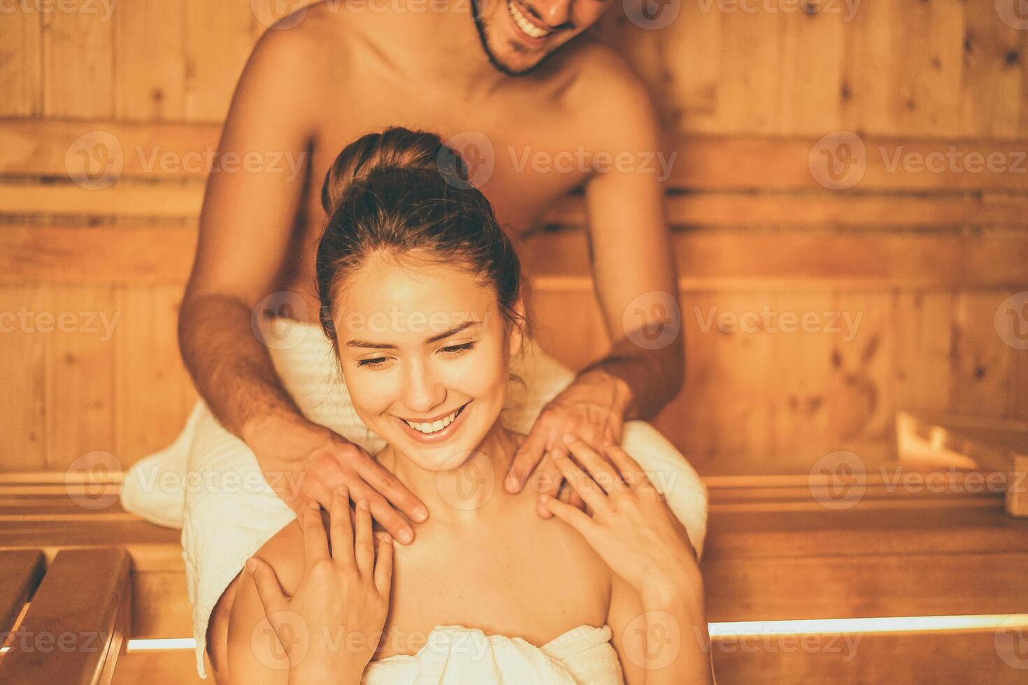 jung glücklich Paar entspannend Innerhalb ein Sauna beim Spa Resort Hotel Luxus - - romantisch Liebhaber haben ein Körperpflege Tag im Dampf Bad Mann Herstellung ein Massage zum seine Freundin - - entspannen, Liebe, Lebensstil Konzept foto