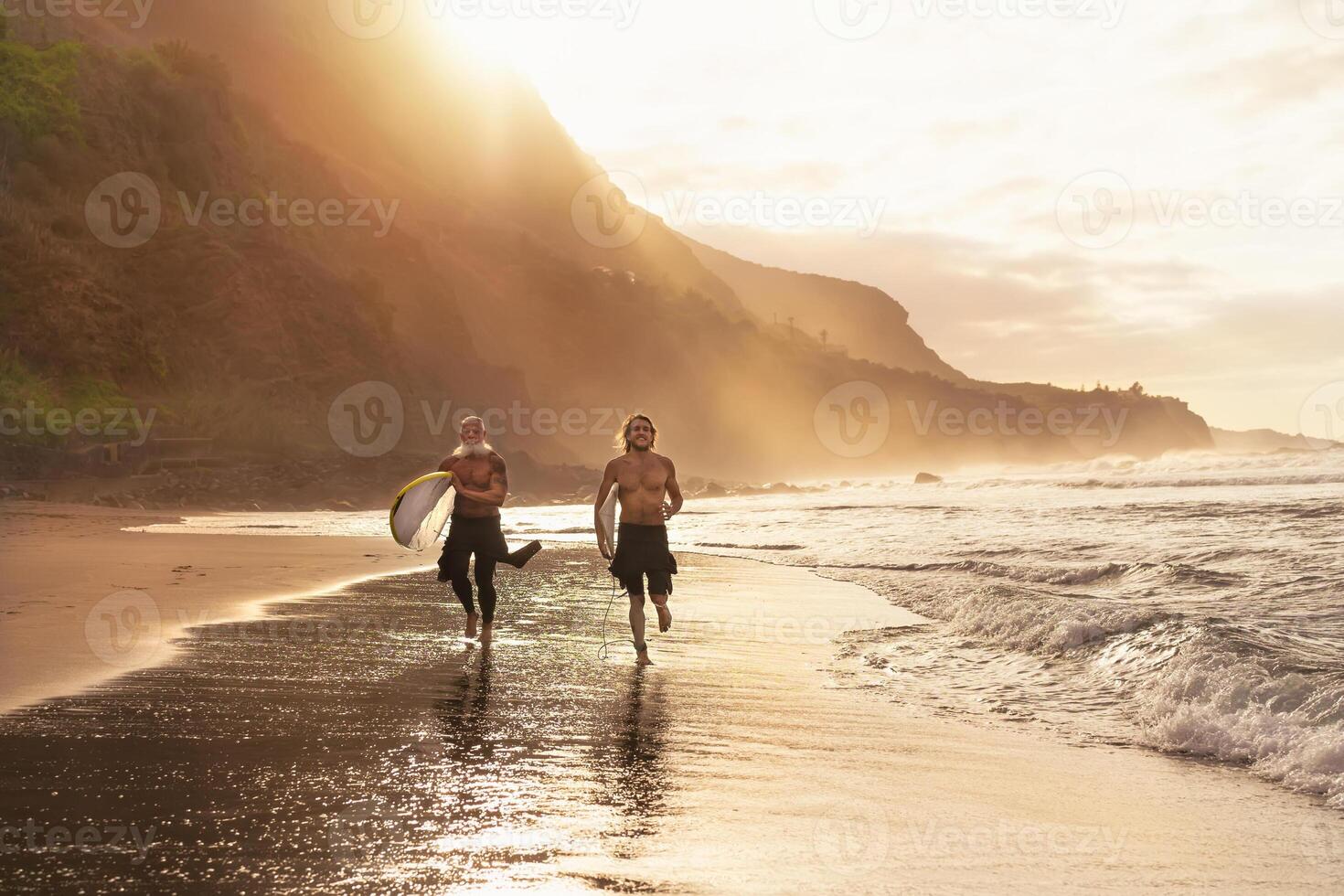 glücklich Surfer Laufen auf Strand mit Surfbretter - - sportlich freunde Surfen und Ausbildung auf Ferien im tropisch Küste - - Menschen extrem Sport Lebensstil Konzept foto