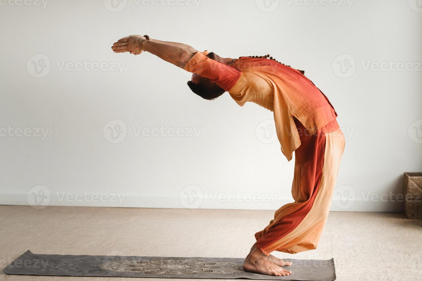 ein Mann im ein Orange passen tut Yoga im ein Fitness Zimmer. das Konzept von Gesundheit foto