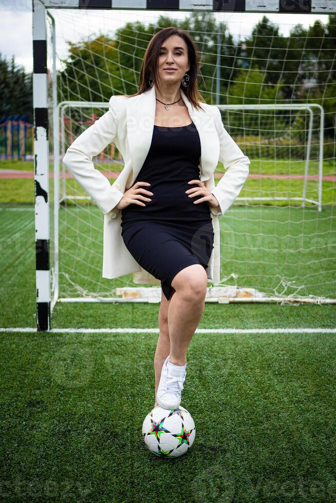 Porträt von ein schön Frau Fußball Spieler im ein streng Büro Anzug. foto