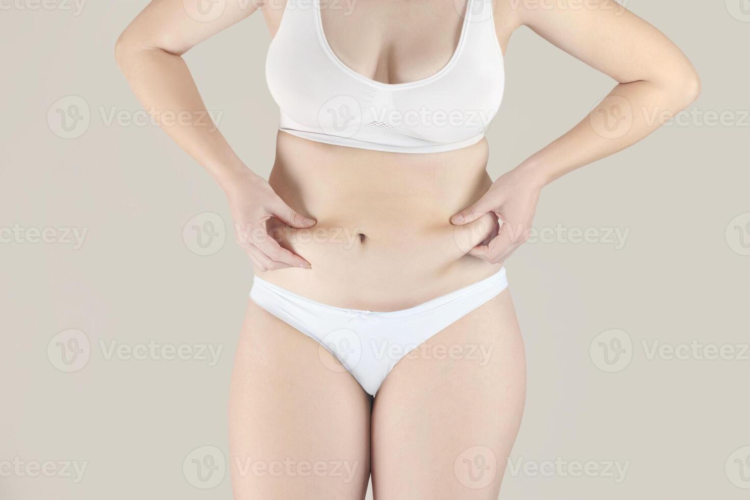 Frau hat Überschuss fett. Mädchen im Unterwäsche zeigt an Bauch fett. sie will zu verlieren Gewicht foto