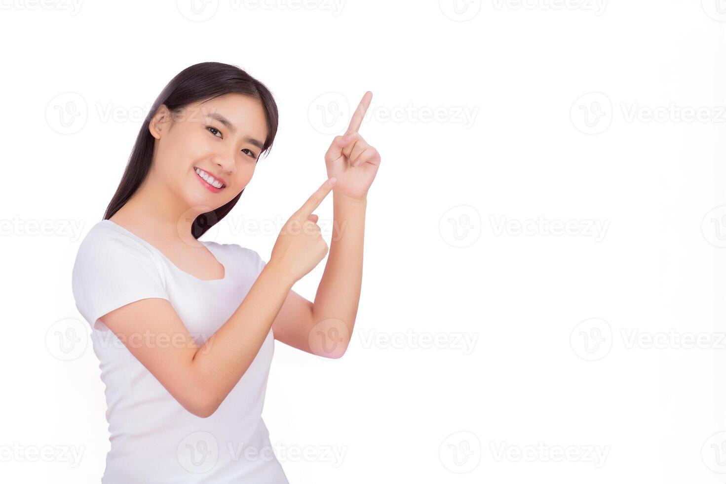 jung asiatisch schön Frau mit schwarz lange Haar im Weiß Hemd zeigt an Hand Punkt oben zu Geschenk etwas während isoliert Weiß Hintergrund. foto